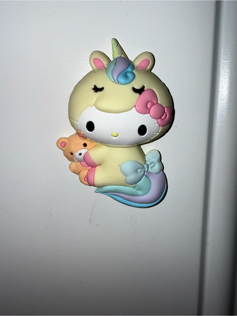 Hello Kitty unicorn magnet with rainbow horn and tail, holding a teddy bear